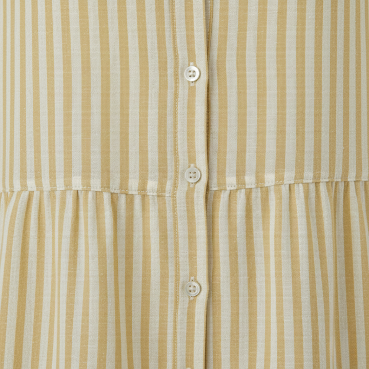  yellow striped shirt dress in a close-up details with a turn-down collar and flowing skirt, ideal for casual gatherings in warm weather.